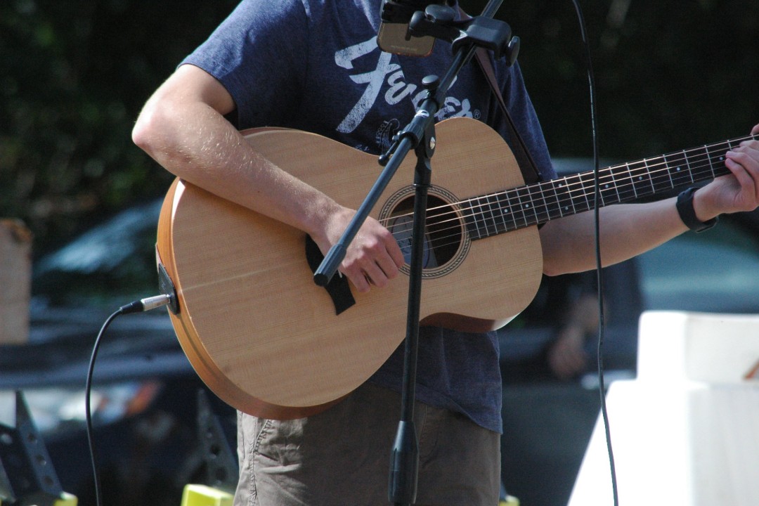 A closeup shot of a busker's guitar