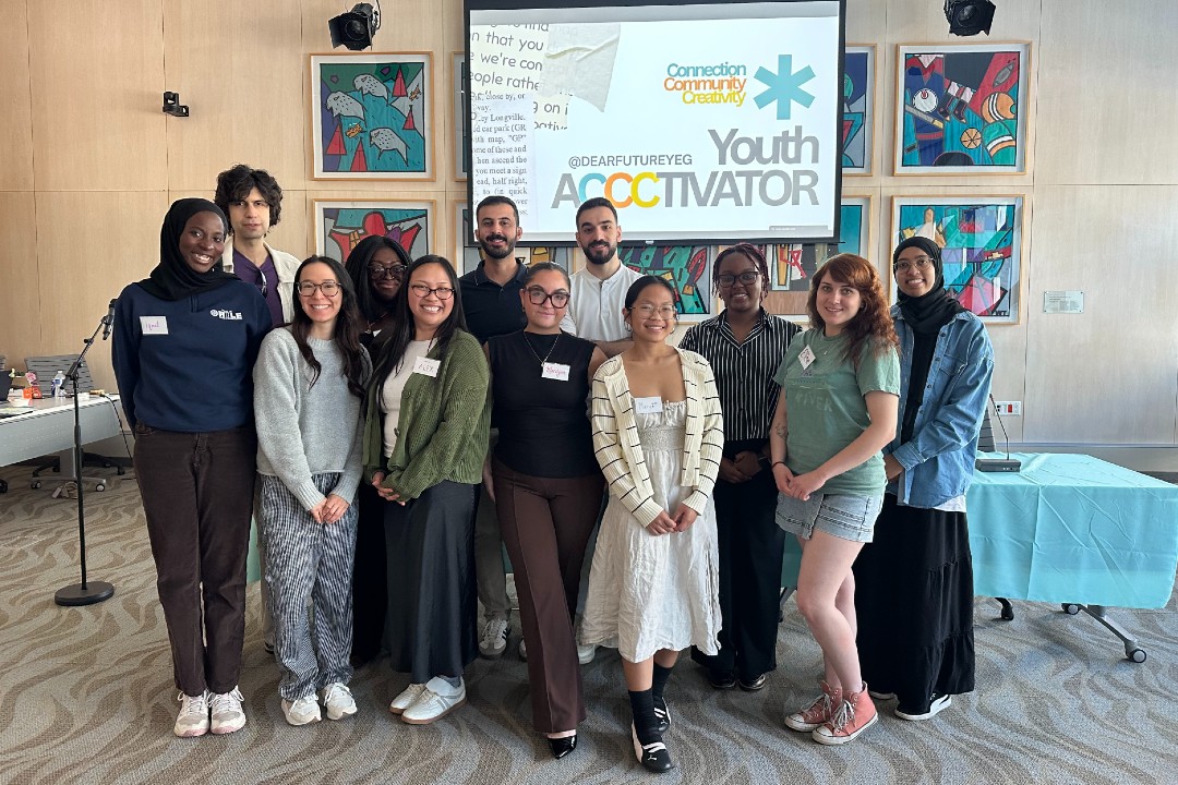 A dozen people stand in front of a screen that says Youth Accctivator