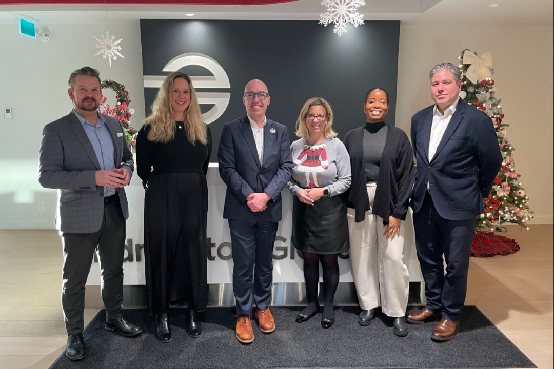 Edmonton Mayor Andrew Knack posing with Edmonton Global personnel alongside holiday season decor