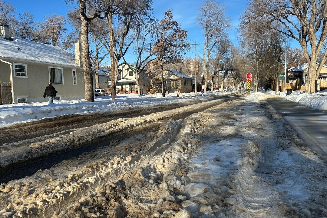 Brown and white snow creates ruts on a sunny street in Strathcona
