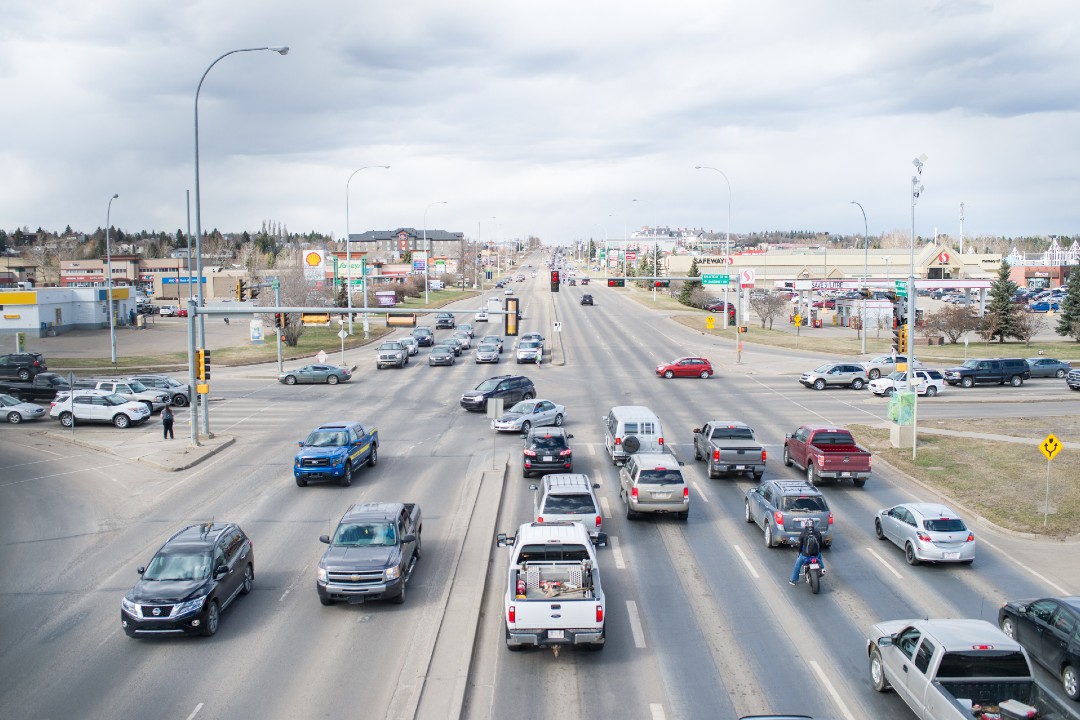 Two roads of about six lanes each intersect, surrounded by commercial development