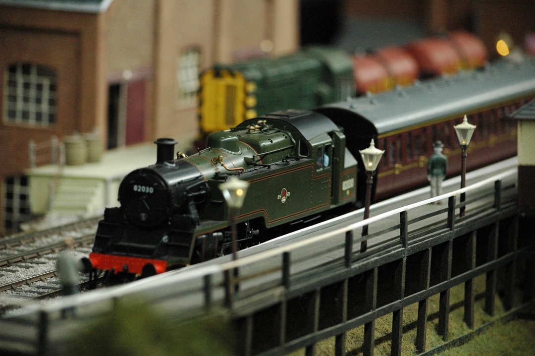 A model train engine crosses a bridge