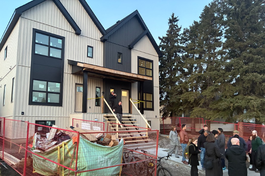 People gathered around an under-construction eightplex
