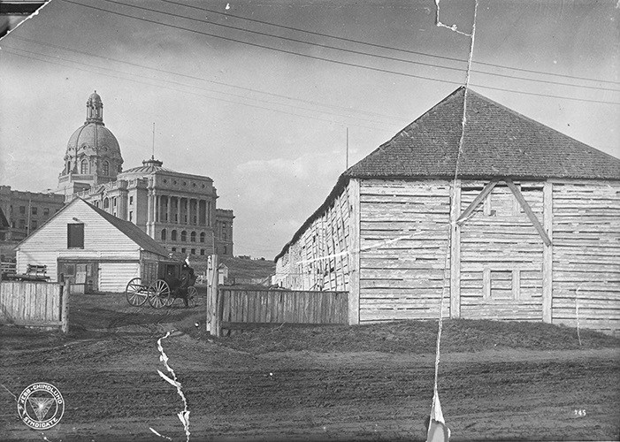 View of the exterior of the Hudson's Bay Company's Fort Edmonton, in front of the new Legislative Building for the Province of Alberta, ca. 1915